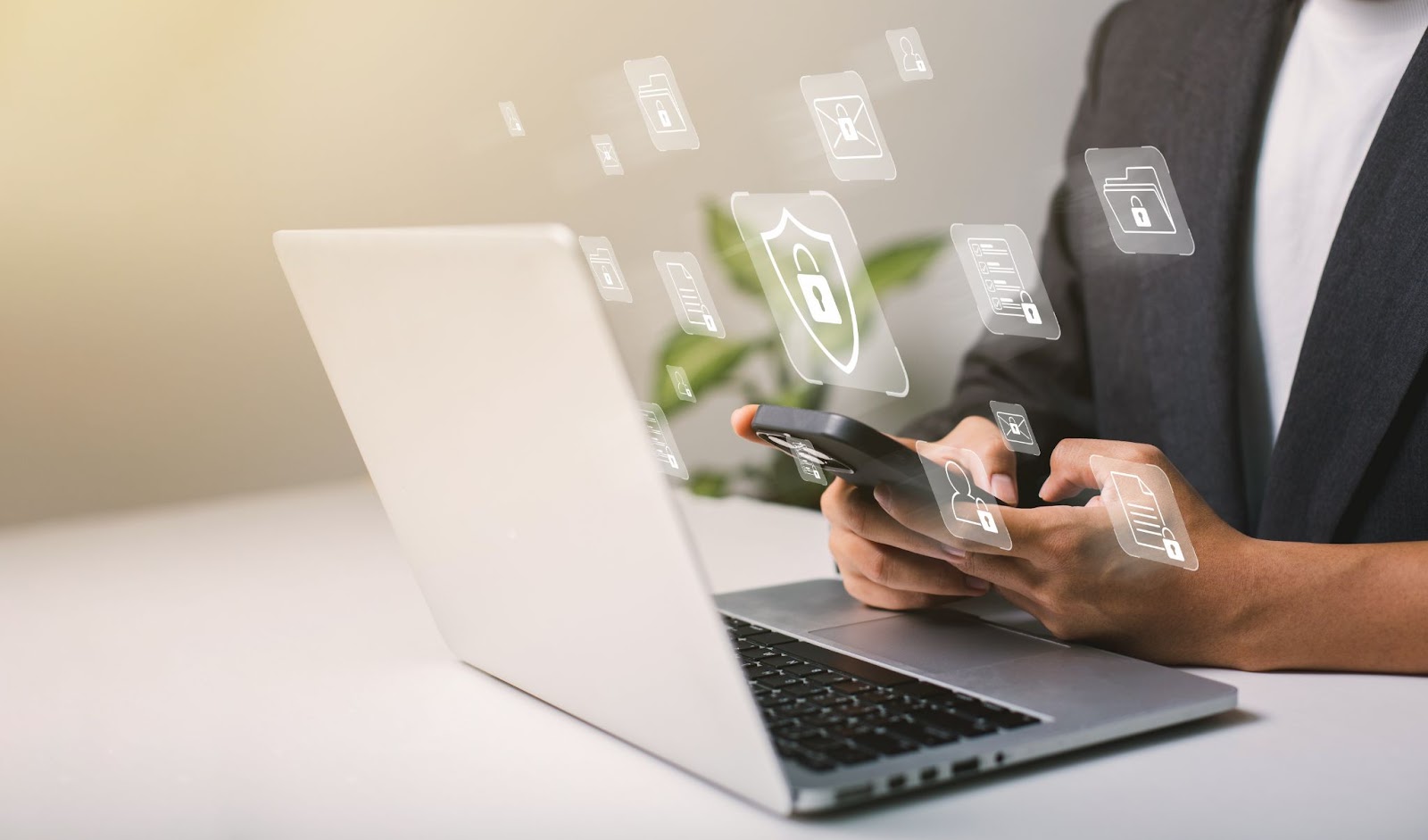 Hands in front of a laptop with icons 